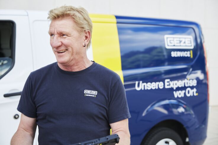 Portrait of service technician Michael Meyer in front of GEZE service vehicle