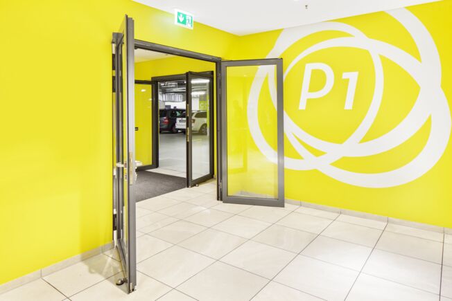 Glazed security interlocking door to the Milaneo parking level, opened.