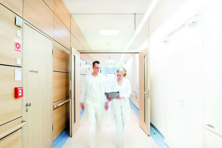 Hospital staff passing through a double-leaf door