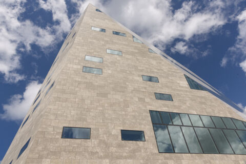 Façade of Forum Groningen photographed from below with differently arranged windows.