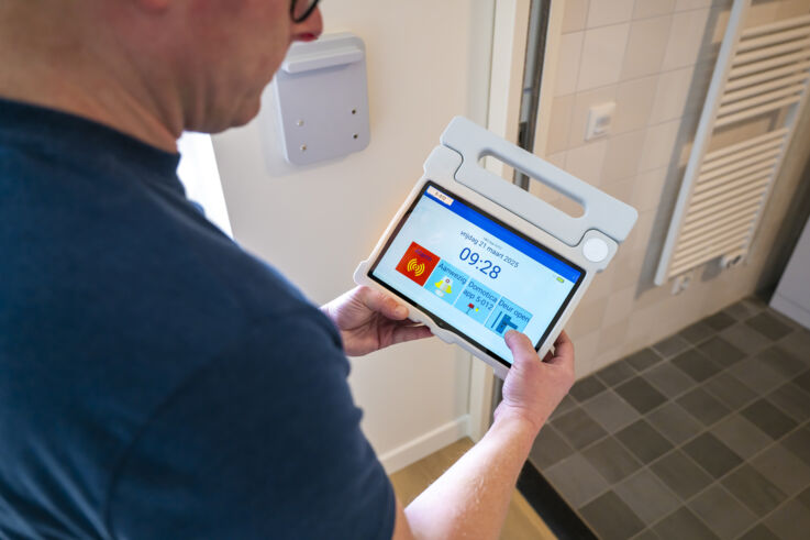 A GEZE service technician looks at a screen displaying the building management system