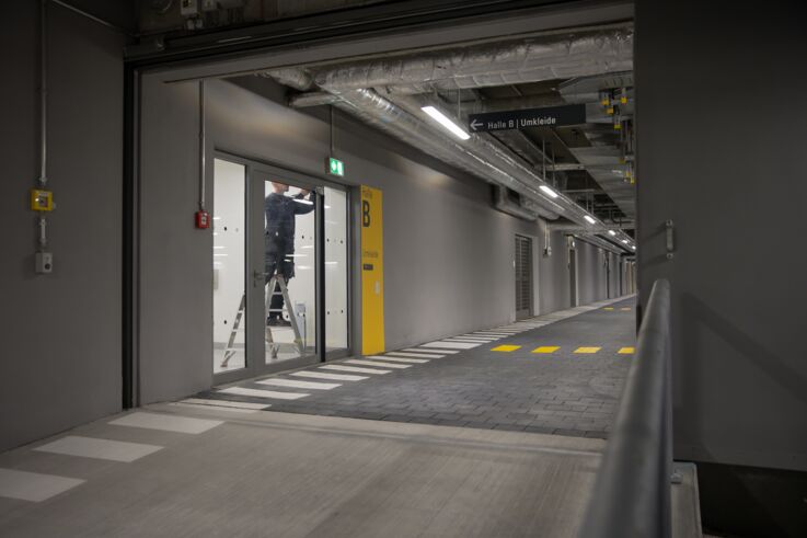 GEZE Service 的服务技术人员正在为一扇大型玻璃门安装闭门器