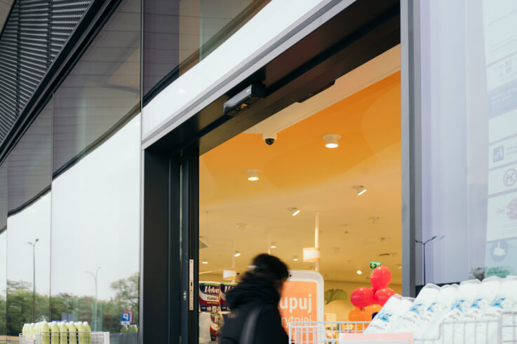 A person enters a dm store through an automatic glass door.